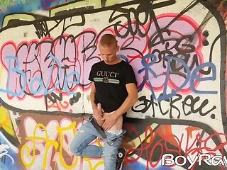 Young guy masturbates in public in front of graffiti wall